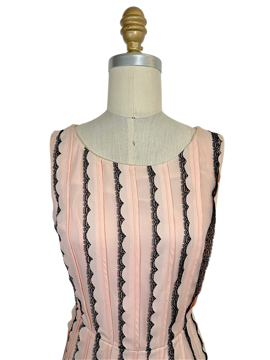 Close-up of the Oscar de la Renta Resort 2014 blush pink dress highlighting the rounded neckline, tailored bodice, and vertical black lace stripe detailing.