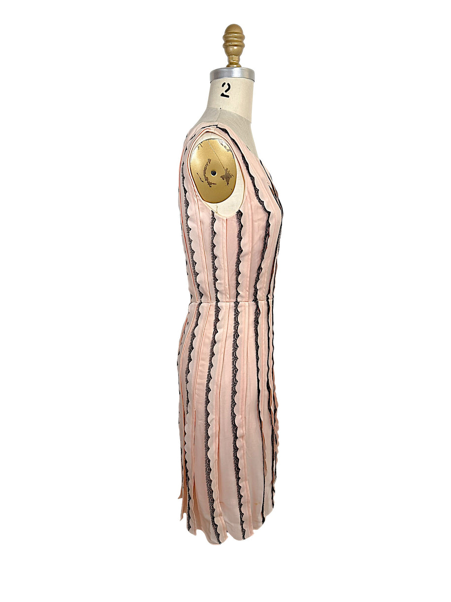 Left side profile of an Oscar de la Renta Resort 2014 blush pink sleeveless dress showing its tailored fit, waist seam, and softly flared skirt.
