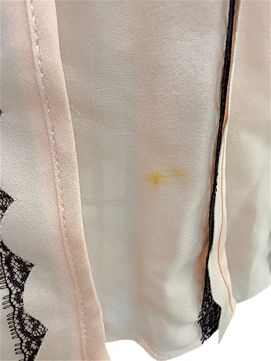 Close-up of light soiling between the front skirt pleats on the Oscar de la Renta Resort 2014 blush pink dress as documented for condition accuracy.