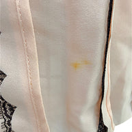 Close-up of light soiling between the front skirt pleats on the Oscar de la Renta Resort 2014 blush pink dress as documented for condition accuracy.