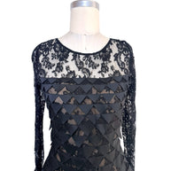 Front upper detail of Oscar de la Renta Resort 2018 black lace dress with illusion neckline and layered geometric appliqué