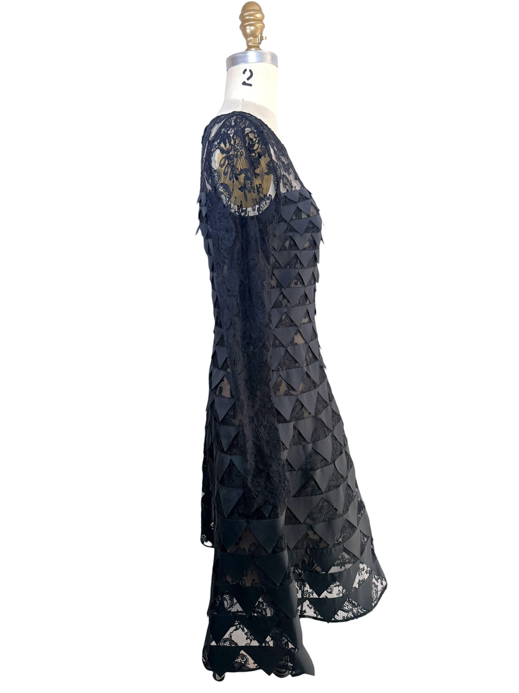 Left side profile of Oscar de la Renta Resort 2018 black lace appliqué cocktail dress with sheer sleeves