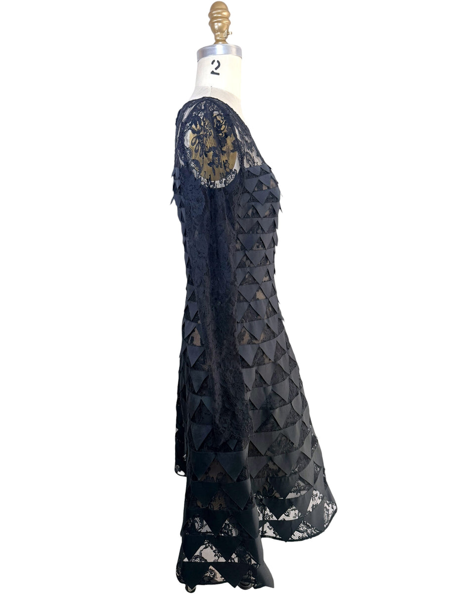 Left side profile of Oscar de la Renta Resort 2018 black lace appliqué cocktail dress with sheer sleeves