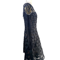 Left side profile of Oscar de la Renta Resort 2018 black lace appliqué cocktail dress with sheer sleeves