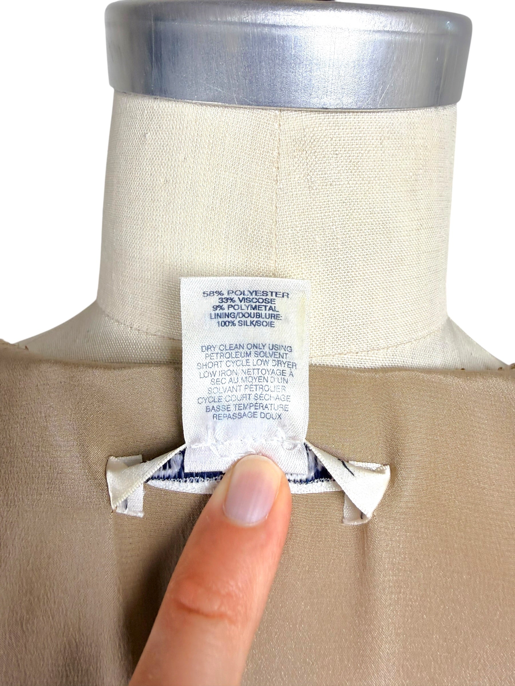 Close-up of Oscar de la Renta Resort 2018 dress fabric composition and care instruction tag showing silk lining and metallic blend composition