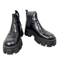 Prada Monolith black leather Chelsea ankle boots size 38 with chunky lug soles, front angled view