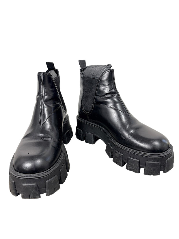 Prada Monolith black leather Chelsea ankle boots size 38 with chunky lug soles, front angled view