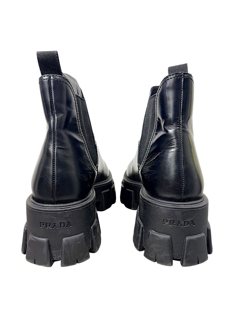 Rear view of Prada Monolith black leather Chelsea boots showing Prada logo embossed on chunky heels