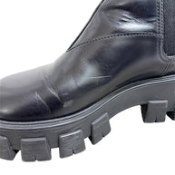 Close-up of Prada Monolith Chelsea boot showing surface scuffs and creasing on black leather upper and lug sole
