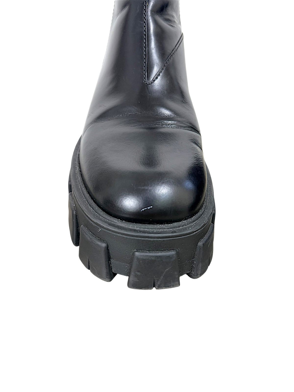 Close-up of Prada Monolith black leather Chelsea boot toe showing small scuff and condition of chunky lug sole