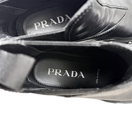 Interior of Prada Monolith black leather Chelsea boots showing Prada branded insoles and Made in Italy marking