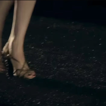10-second archival runway video of Chanel Pre-Fall 2010 Paris-Shanghai Métiers d'Art Collection Look 42, showing Karl Lagerfeld's ivory bouclé skirt suit with signature navy and crimson braided trim as presented on the Shanghai runway. Included as a historical runway reference for the documented ensemble.