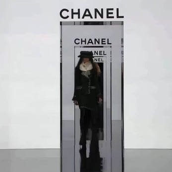 14-second runway video of Chanel Fall 2009 Runway Look 22 under Karl Lagerfeld, featuring the original black bouclé tweed jacket and matching skirt with ivory fringe trim, emerald green accents, oversized tweed hat, and ivory fur collar as presented on the Paris runway.