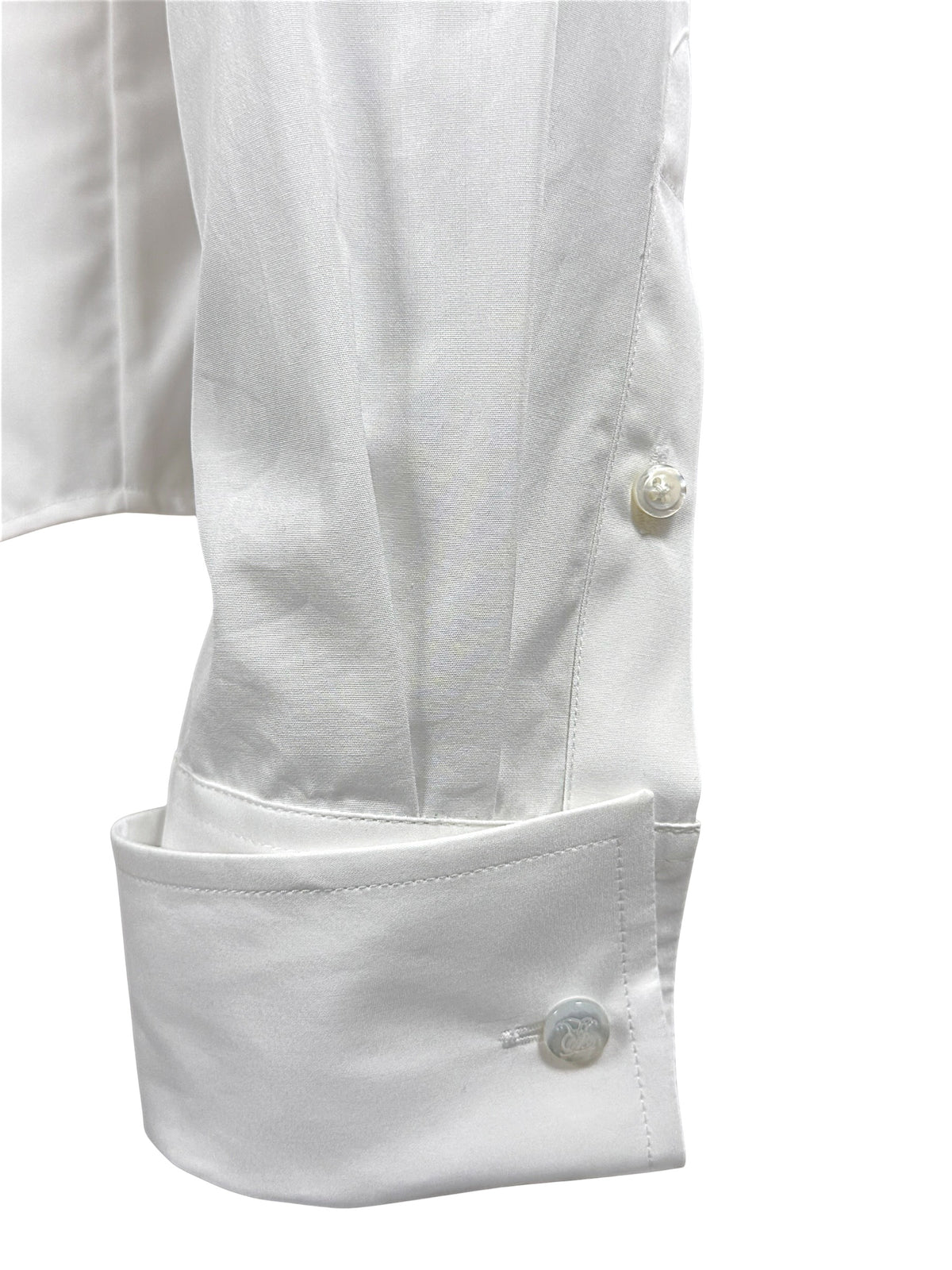 Close-up of Ralph Lauren Purple Label white cotton tuxedo shirt sleeve with elongated formal cuff and engraved button detailing.