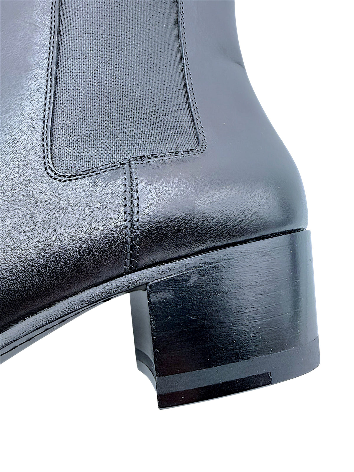 Close-up of Saint Laurent Paris black leather Chelsea boot showing elastic side gusset, stitched leather panels and lightly scuffed block heel.