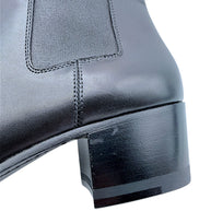 Close-up of Saint Laurent Paris black leather Chelsea boot showing elastic side gusset, stitched leather panels and lightly scuffed block heel.