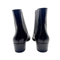Rear view of Saint Laurent Paris black leather Chelsea ankle boots showing stitched back seams, low stacked heels and ankle shafts.