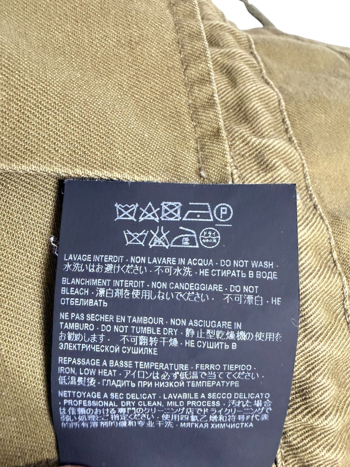 Saint Laurent Paris military utility jacket interior care label with professional dry cleaning instructions and garment care symbols.