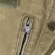 Close-up of Saint Laurent Paris engraved zipper pull on olive green cotton twill military jacket with distressed finish