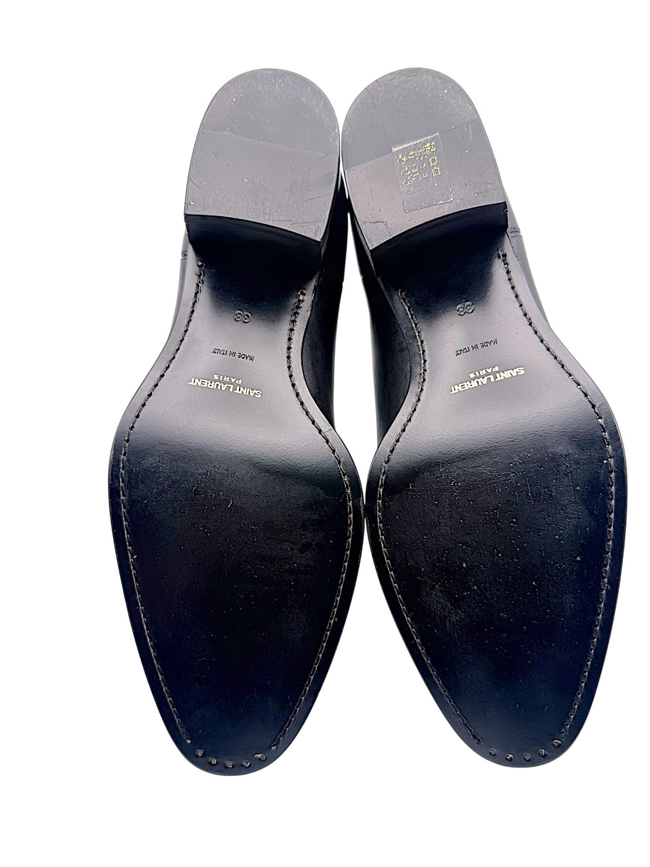 Full underside view of Saint Laurent Paris black leather Chelsea ankle boots, size EU 38, showing Made in Italy markings, gold branding and light wear on leather soles and heels.