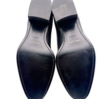 Full underside view of Saint Laurent Paris black leather Chelsea ankle boots, size EU 38, showing Made in Italy markings, gold branding and light wear on leather soles and heels.