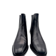 Front view of Saint Laurent Paris black leather Chelsea ankle boots showing sleek almond-shaped toes and natural leather creasing.