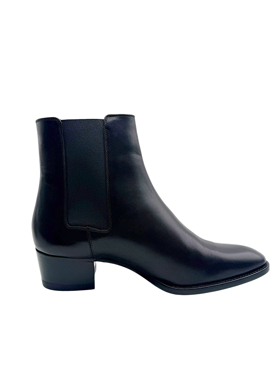 Side view of Saint Laurent Paris black leather Chelsea boot highlighting the elastic ankle gusset, streamlined silhouette and block heel.