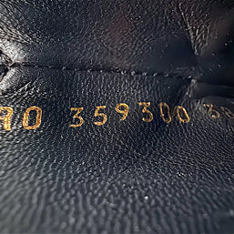 Close-up of gold stamped Saint Laurent Paris footwear reference code inside black leather Chelsea ankle boot, showing interior leather texture and identification markings.