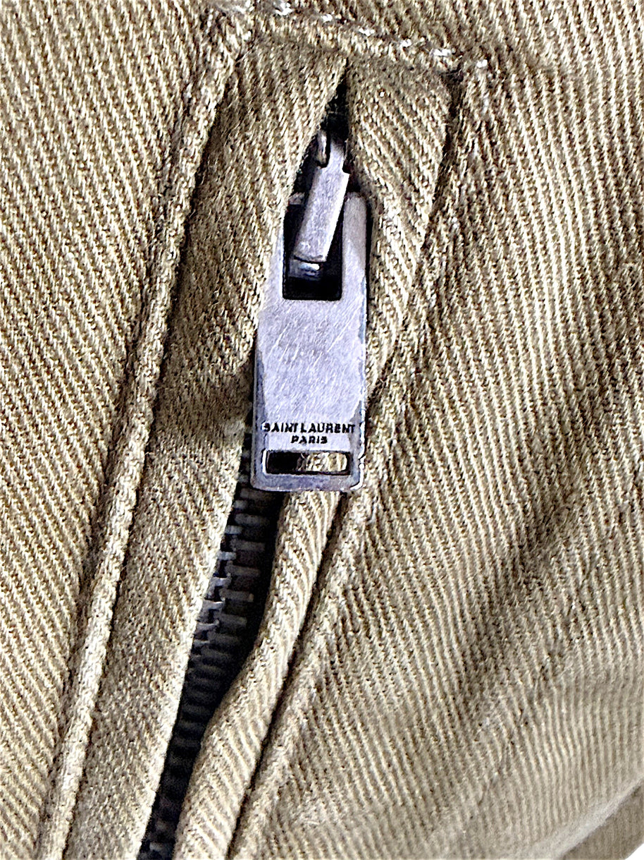 Detailed view of Saint Laurent Paris branded metal zipper and stitching on Fall 2018 olive green military utility jacket