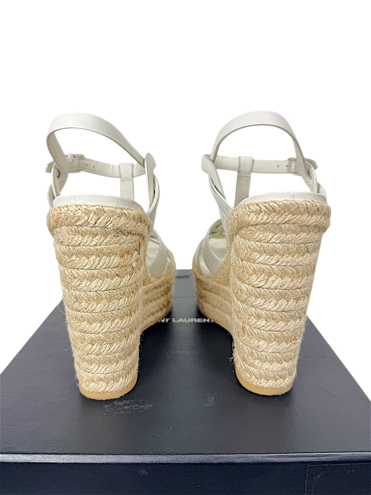 Rear view of Saint Laurent Tribute white leather sandals showing natural braided jute platform wedge and ankle straps