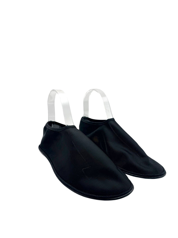 Women's The Row black mesh sock flats, alternate three-quarter front view highlighting sheer ribbed textile, rounded toes and tonal trim.