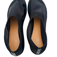 Top interior view of The Row black mesh sock ballet flats featuring tan leather insoles, gold-tone The Row branding and black heel tabs.
