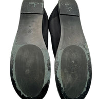 Bottom view of The Row black mesh sock flats, EU size 38, showing both outsoles with visible surface wear, scuffing and peeling finish around the edges and heels.