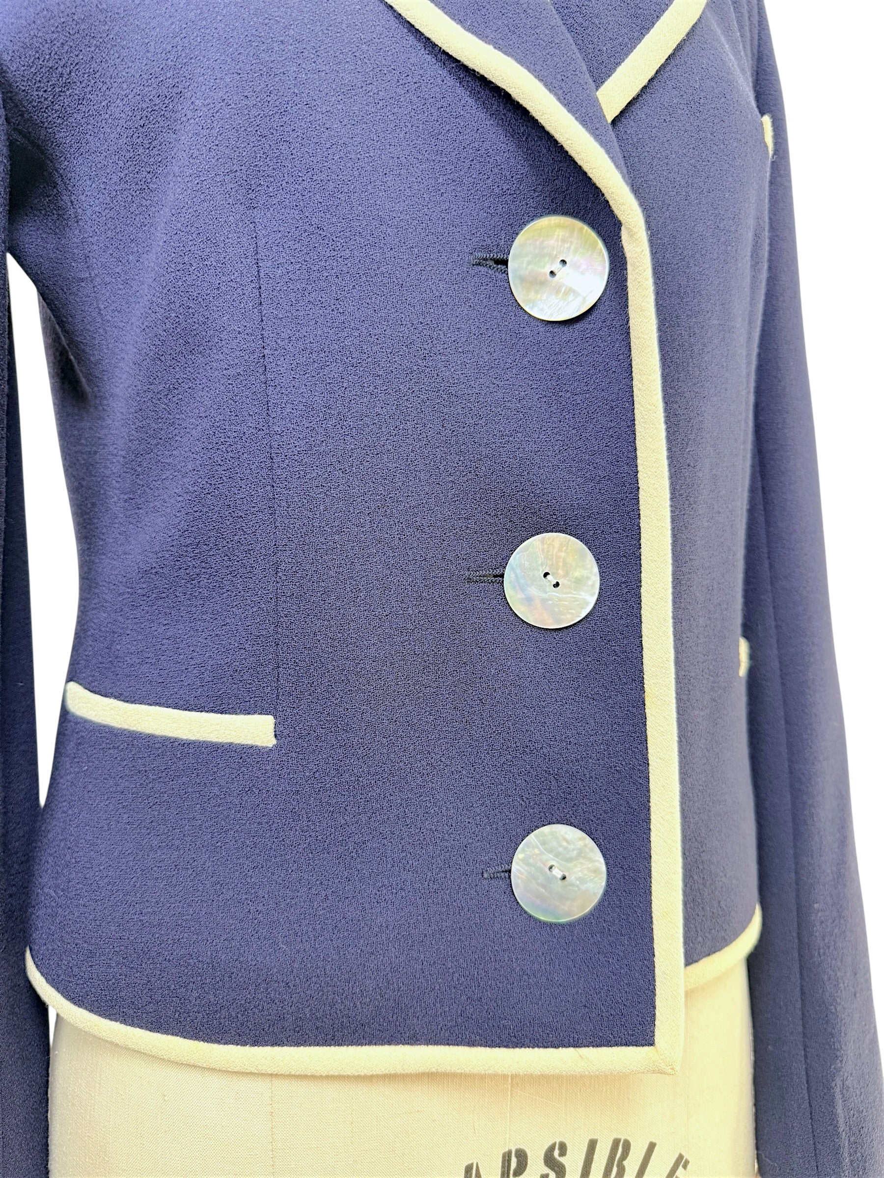 Close-up detail of Valentino blazer mother-of-pearl buttons and ivory piping