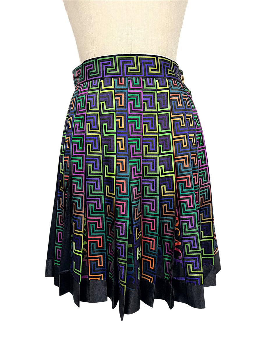 Front view of Versace Fall Winter 2021 La Greca pleated skirt featuring a multicolor geometric Greek Key print and black hem on a US size 2 mannequin.