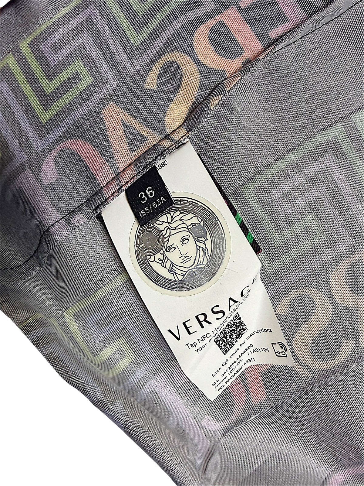 Close-up of Versace Fall Winter 2021 La Greca pleated skirt interior showing Italian size 36 label, Medusa emblem, NFC authentication tag and printed fabric.