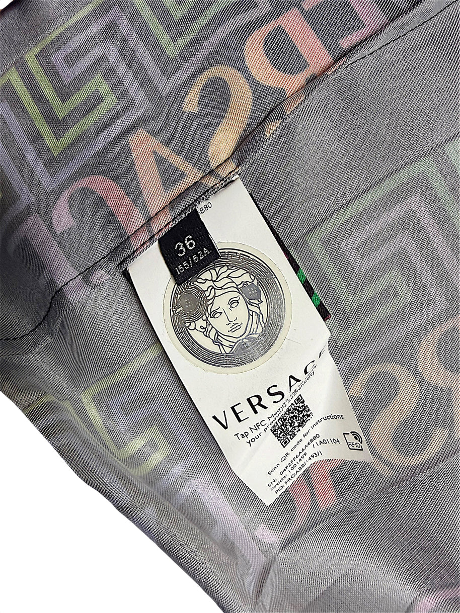 Close-up of Versace Fall Winter 2021 La Greca pleated skirt interior showing Italian size 36 label, Medusa emblem, NFC authentication tag and printed fabric.