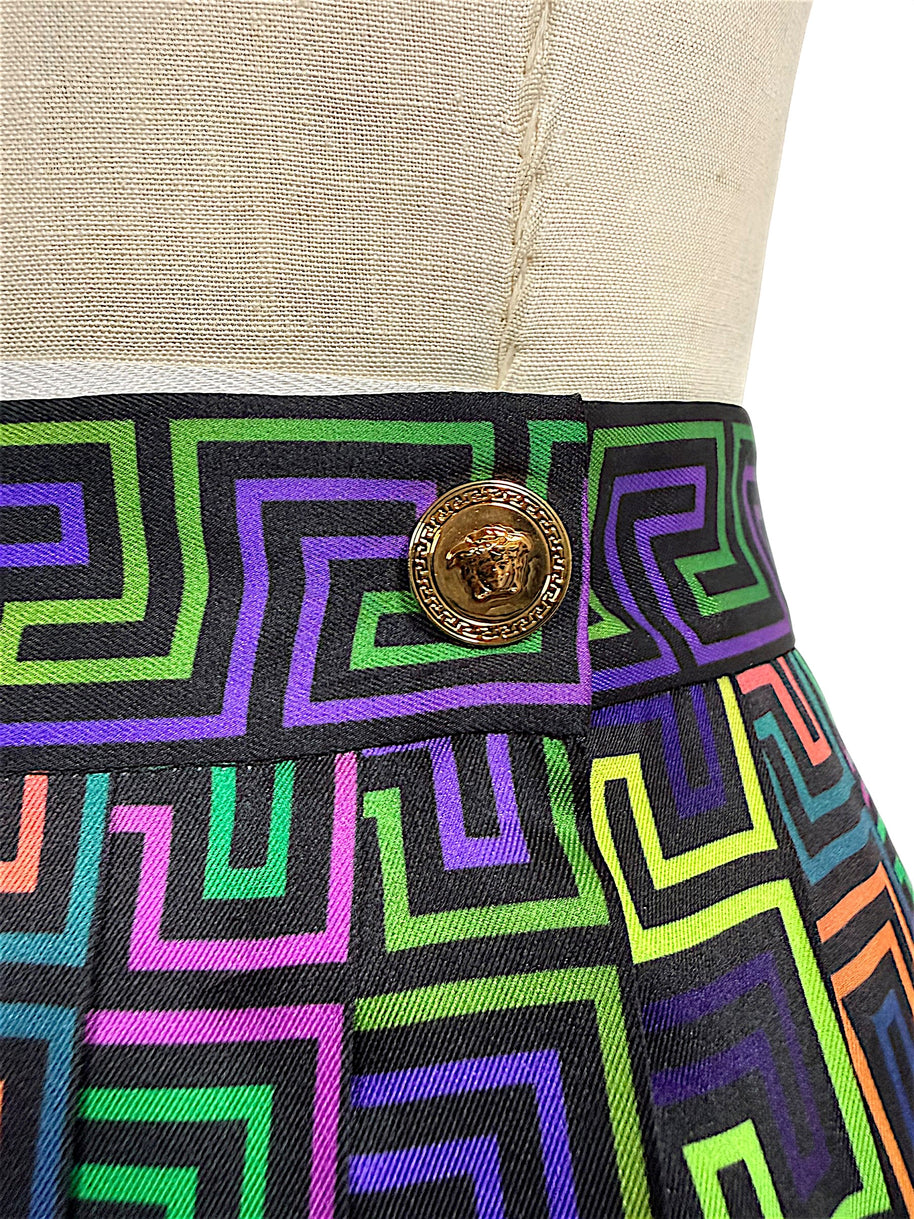 Close-up of gold-tone Versace Medusa head button framed by a Greek Key border on the multicolor La Greca patterned waistband.