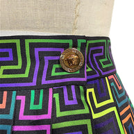 Close-up of gold-tone Versace Medusa head button framed by a Greek Key border on the multicolor La Greca patterned waistband.