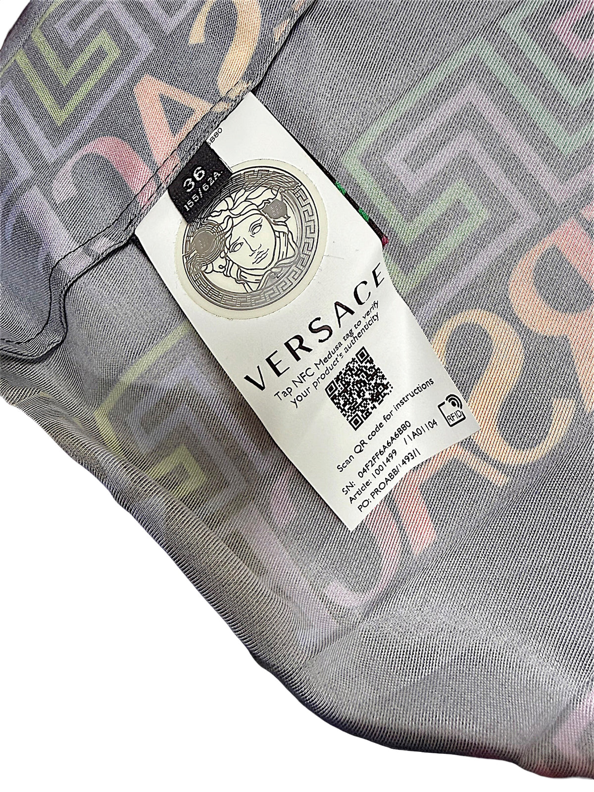 Versace La Greca pleated skirt interior tag showing Italian size 36, Medusa emblem and NFC product authentication information.