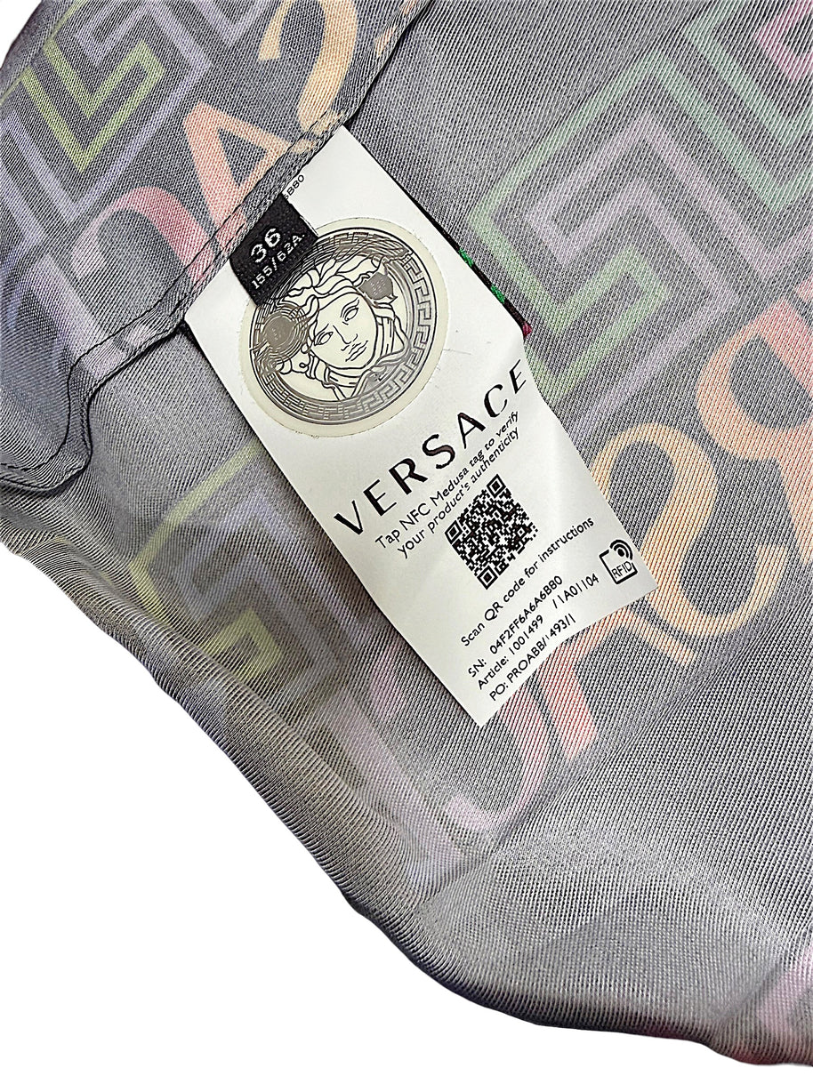 Versace La Greca pleated skirt interior tag showing Italian size 36, Medusa emblem and NFC product authentication information.