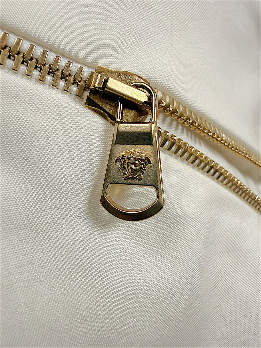Close-up of Medusa logo gold-tone zipper hardware on Versace Spring 2009 runway dress