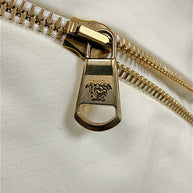 Close-up of Medusa logo gold-tone zipper hardware on Versace Spring 2009 runway dress