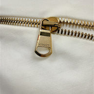 Close-up of Versace engraved gold-tone zipper pull on Spring 2009 ivory dress