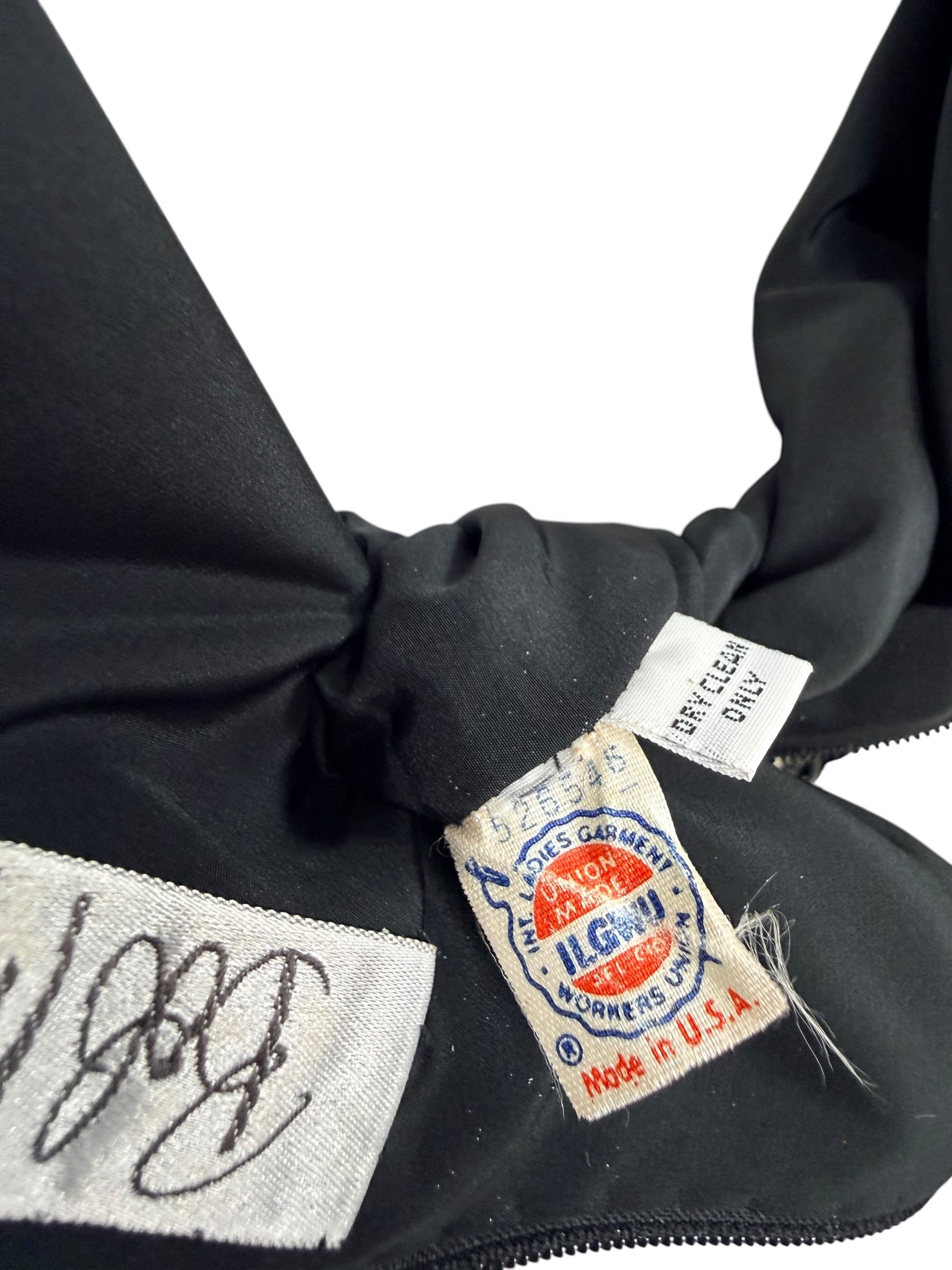 Close-up of vintage ILGWU union and Made in USA labels inside Bob Mackie black beaded dress
