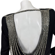Close-up of dramatic open back framed with dense silver bugle bead embroidery on vintage Bob Mackie dress