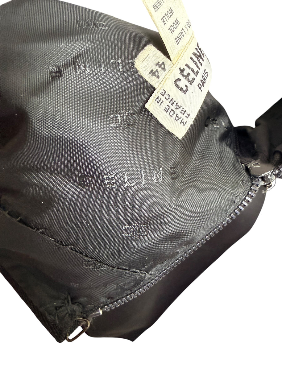 Interior of vintage Céline black wool skirt showing woven Céline logo jacquard lining, original designer label, and rear zipper construction.