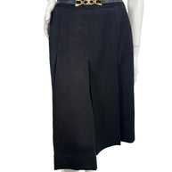 Vintage Céline black wool pleated midi skirt shown from the front with integrated leather waistband and gold-tone Double-C logo hardware.