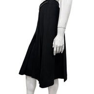 Opposite side view of vintage Céline black wool skirt showing the flared midi silhouette, deep pleats, and integrated leather waistband.