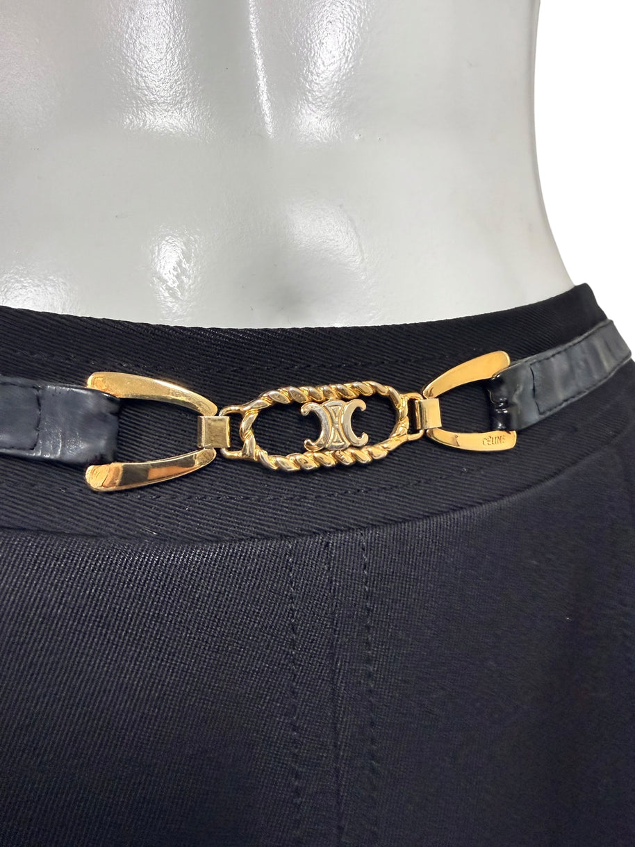 Detailed close-up of gold-tone Céline Double-C logo hardware with rope-style oval frame and black leather belt on vintage wool skirt.